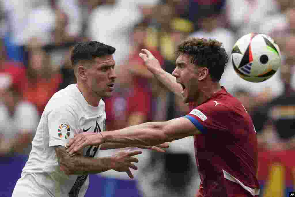 Serbia's Dusan Vlahovic, right, and Slovenia's Erik Janza vie for the ball during a Group C match between Slovenia and Serbia at the Euro 2024 soccer tournament in Munich, Germany.