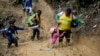 Foto Achiv: Yon dam leve timoun ni soti nan labou pandan migran Ekwatoryen ap travese Pas Darien nan soti Kolonbi pou antre Panama ak espwa pou yo rive Ozetazini, 15 Oktob, 2022. 