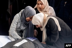 Palestinke oplakuju rođaka člana porodice ubijenog u noćnim izraelskim bombardovanjima juga Pojasa Gaze, stojeći nad njegovim tijelom u bolnici u Rafi, 8. februara 2024.