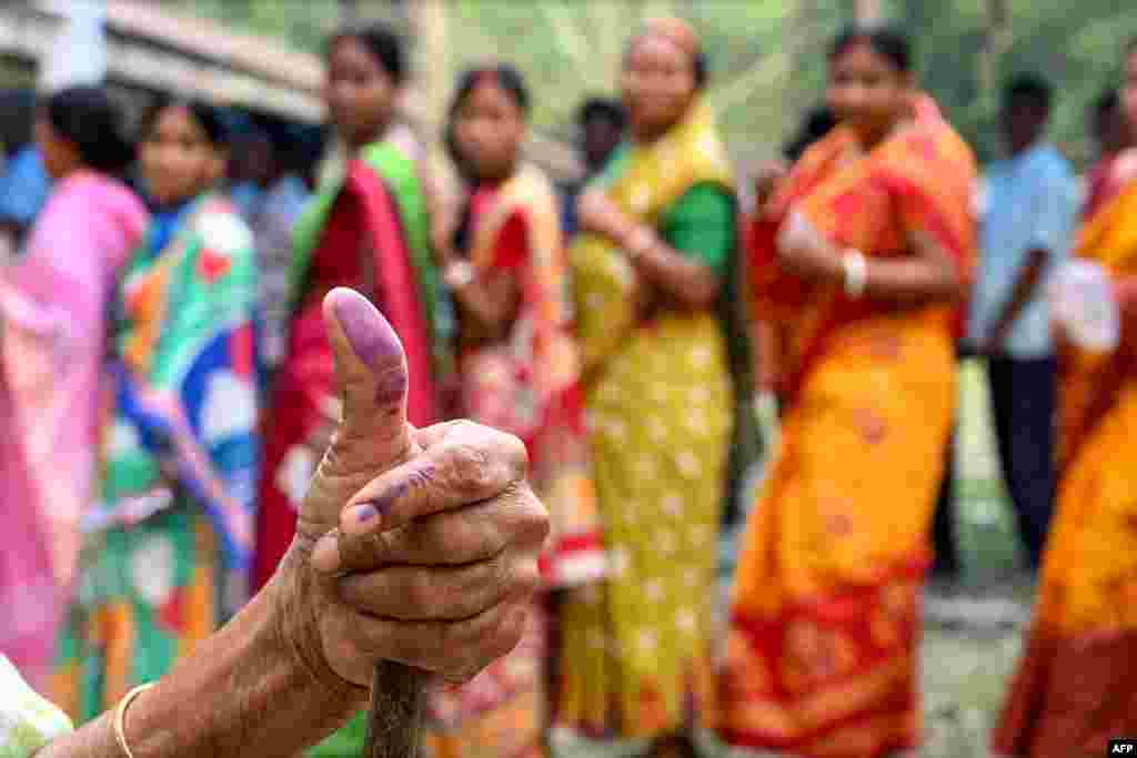 A woman shows her inked finger after casting her ballot to vote in the first phase of India's general election at a polling station in Kalamati village, Dinhata district of Cooch Behar in the country's West Bengal state.