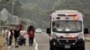 Una ambulancia pasa junto a migrantes que caminan hacia Huehuetán, estado de Chiapas, México, el lunes 24 de abril de 2023.