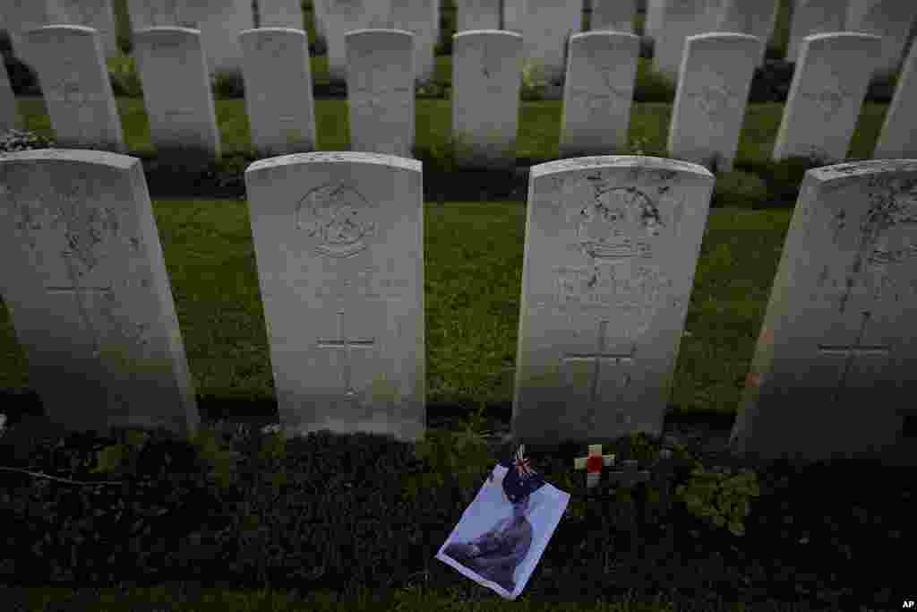 A photo and flag are left at the grave of World War I Australian soldier Alan Humphrey Scott during an ANZAC Day dawn service at Buttes New British Cemetery in Zonnebeke, Belgium. ANZAC Day is a national day of remembrance in Australia and New Zealand for those who served in all wars.