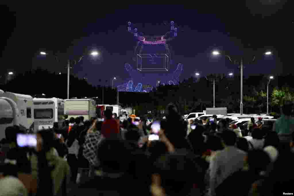 People watch drones' formation flying at the World Drone Light Show 2024, which is a part of the 2024 Korea Drone Expo, in Incheon, South Korea.