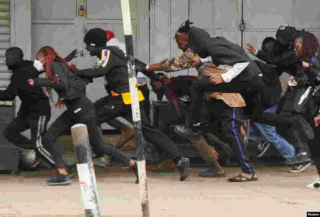People run after police officers used teargas to disperse protesters during a demonstration over police killings of people protesting against Kenya's proposed finance bill 2024/2025, in Nairobi.