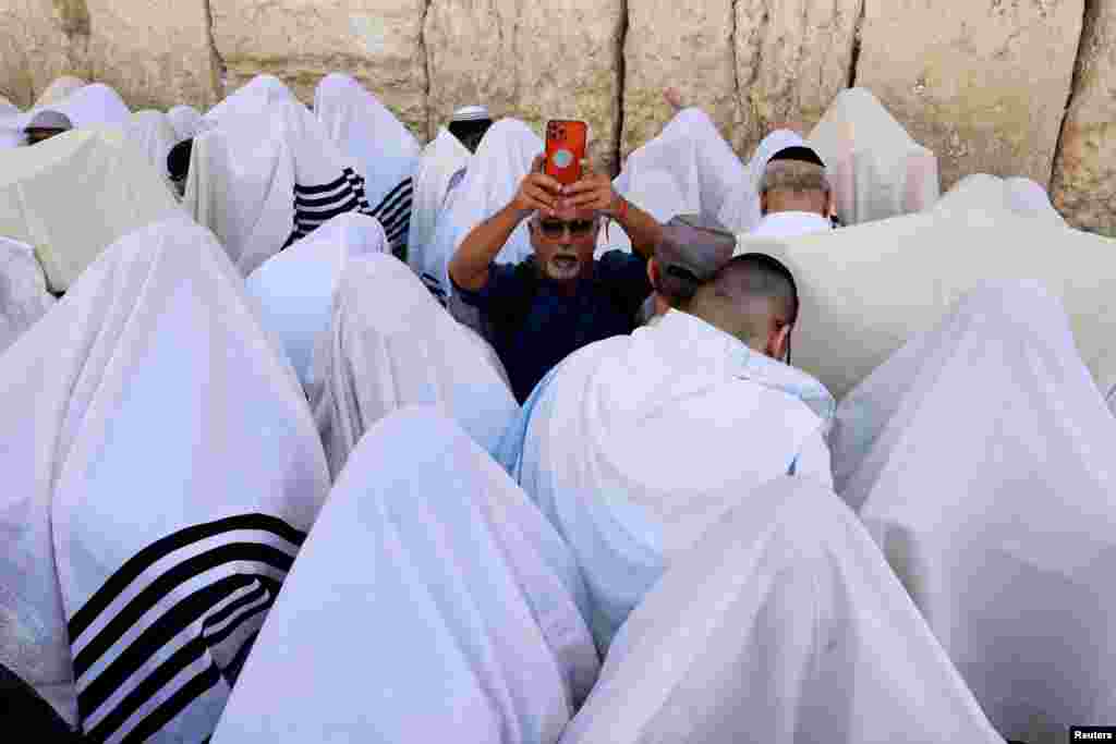 Jewish worshippers cover themselves in their prayer shawls, as they pray during a priestly blessing on the Jewish holiday of Passover, at the Western Wall, Judaism's holiest prayer site, followed by a special pray for the hostages held in Gaza, the well-being of the Israeli soldiers, the Jewish nation and for healing of the injured, in Jerusalem's Old City.