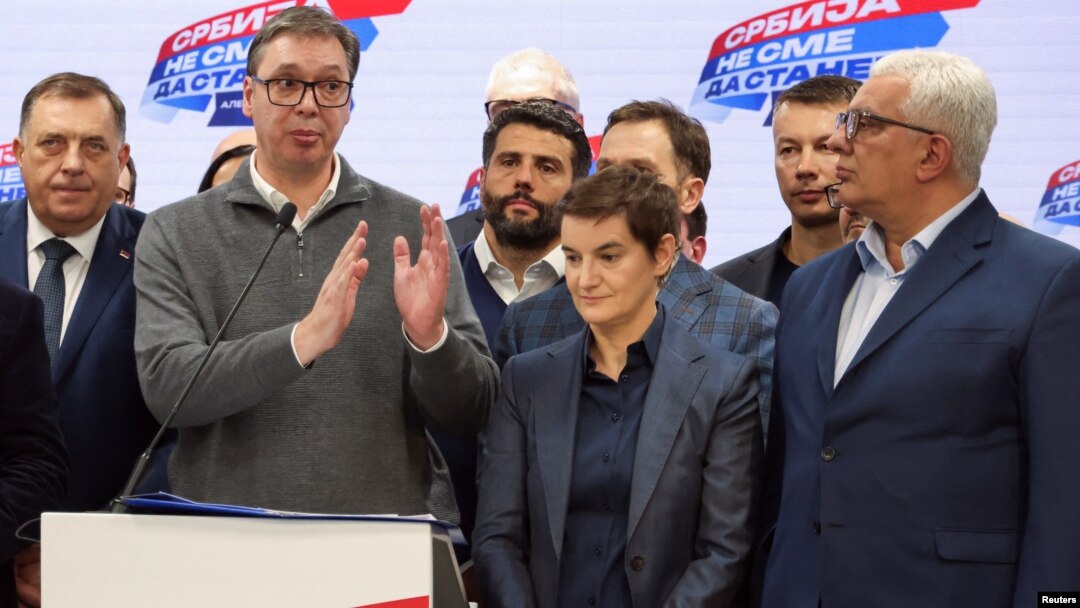 Predsednik Skupštine Crne Gore Andrija Mandić (desno) stoji pored premijerke Srbije Ane Brenabić i predsednika Aleksandra Vučića, u izbornom štabu Srpske napredne stranke, tokom proglašenja pobede na parlamentarnim izborima u Srbiji, u Beogradu, 17. decembra 2023.