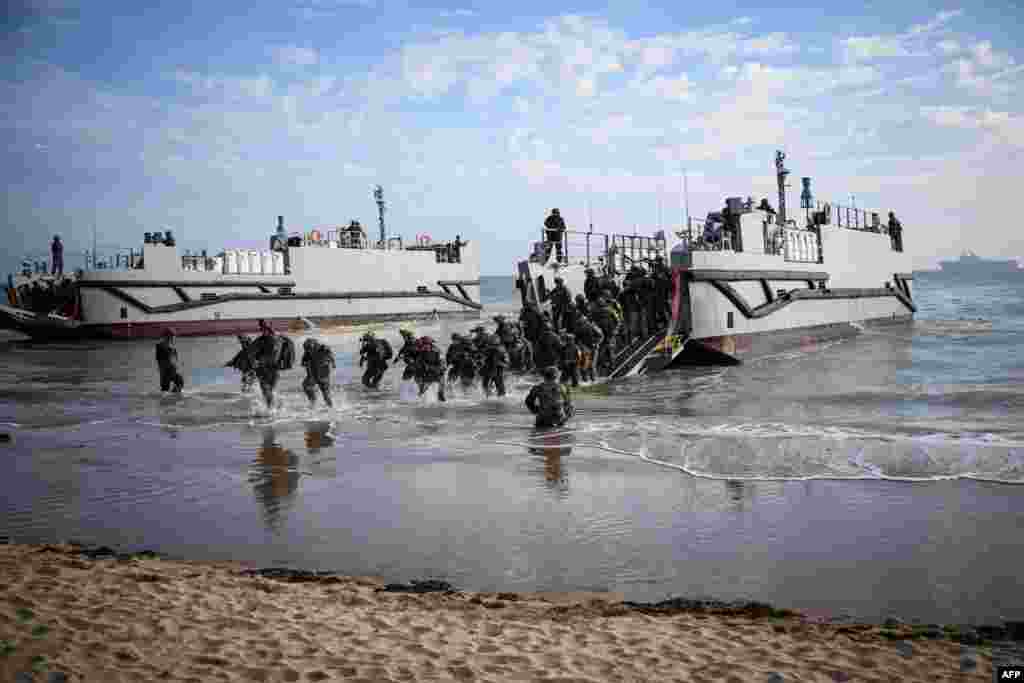 French troops disembark from a U.S. landing craft during a joint U.S. and French amphibious landing operation showcase at Omaha beach in Saint-Laurent-sur-Mer, northwestern France, ahead of the "D-Day" commemorations marking the 80th anniversary of the World War II Allied landings in Normandy.