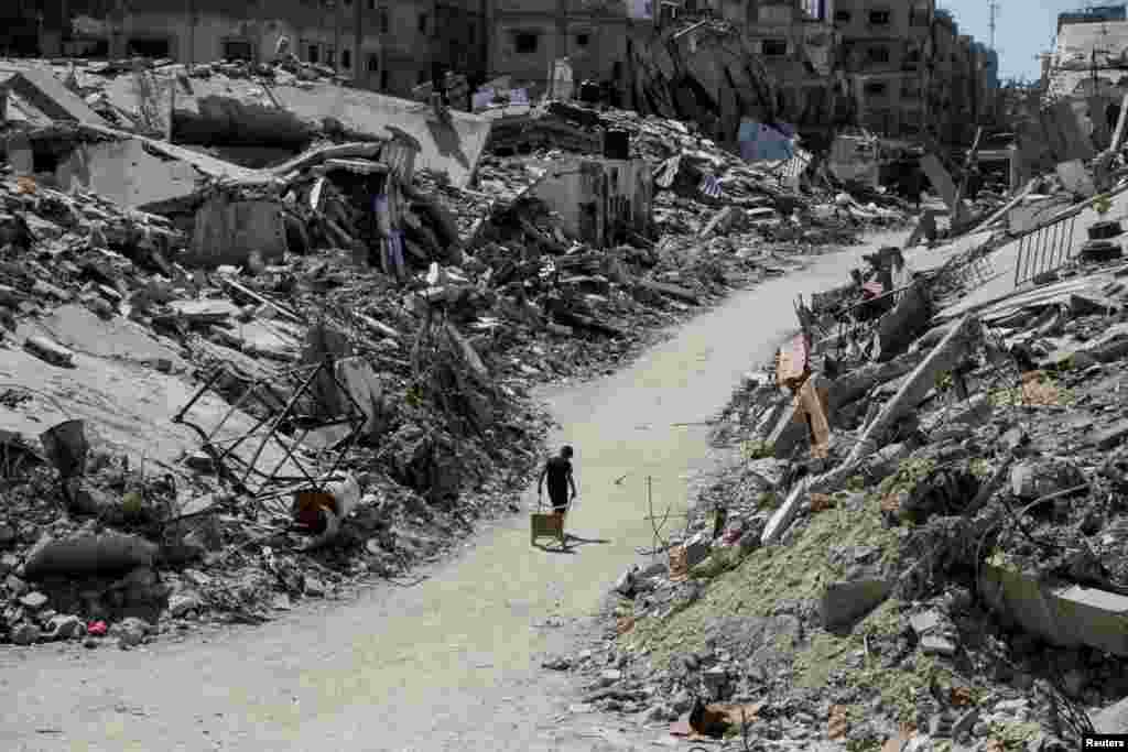 A Palestinian walks among the rubble of damaged buildings, which were destroyed during Israel's military offensive in Beit Lahia in the northern Gaza Strip, June 12, 2024.
