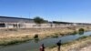 In Ciudad Juárez, Mexico, a woman walks with her son along the Rio Grande on May 11, 2023.