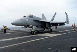 美日韩三国在东中国海举行联合海军军演，一架 F-18E 战斗机正准备从美国海军西奥多·罗斯福号航空母舰上起飞。(2024年4月11日)