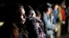ARCHIVO - Una mujer de Cuba espera con otros migrantes para ser procesados para buscar asilo después de cruzar la frontera hacia Estados Unidos, el viernes 6 de enero de 2023, cerca de Yuma, Arizona.
