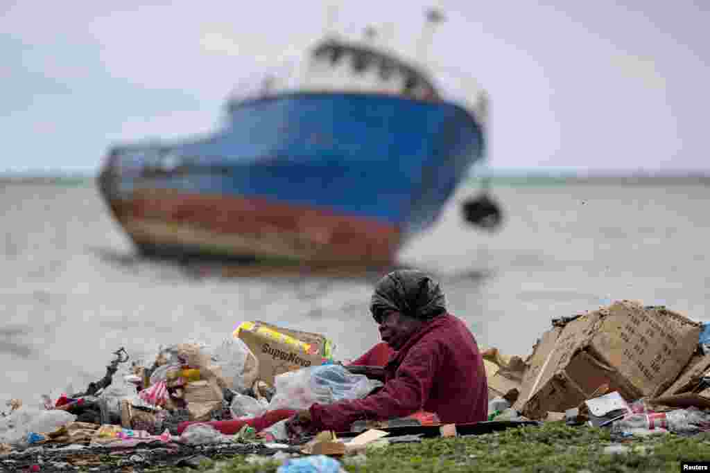 A woman searches for valuables through a pile of garbage in Cap-Haitien, Haiti, April 29, 2024.