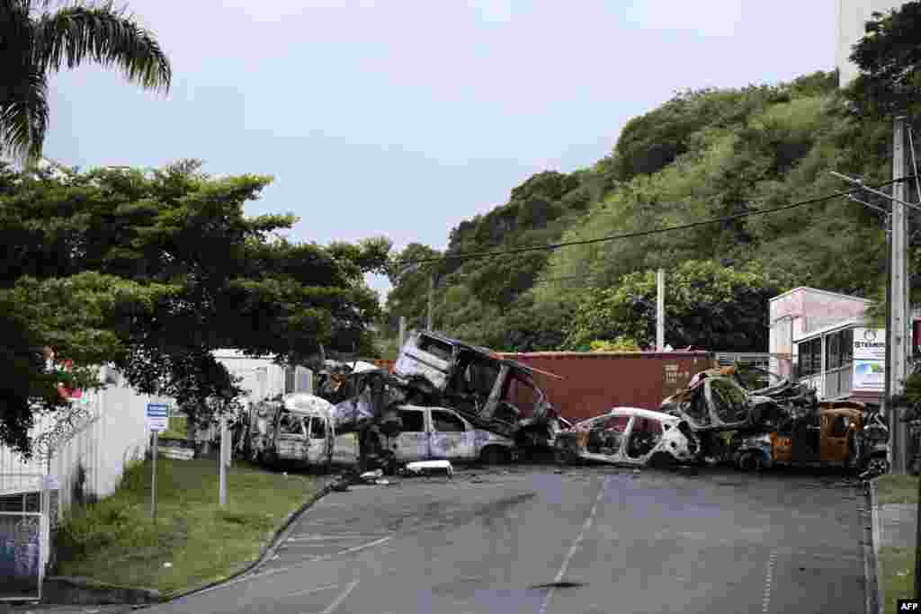 Car wreckages at a makeshift roadblock are seen at the entrance of Ducos industrial zone, in Noumea, France's Pacific territory of New Caledonia. Riots sparked by a constitutional reform project broke out on May 13. France has lifted a state of emergency across the territory after two weeks of unrest in which seven people died and hundreds were injured.