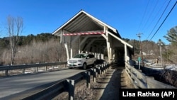 A vehicle passes through the Miller's Run covered bridge in Lyndon, Vt., on Tuesday, March 12, 2024. The historic bridge is under threat from truck drivers relying on GPS meant for cars continually hitting the bridge. (AP Photo/Lisa Rathke)