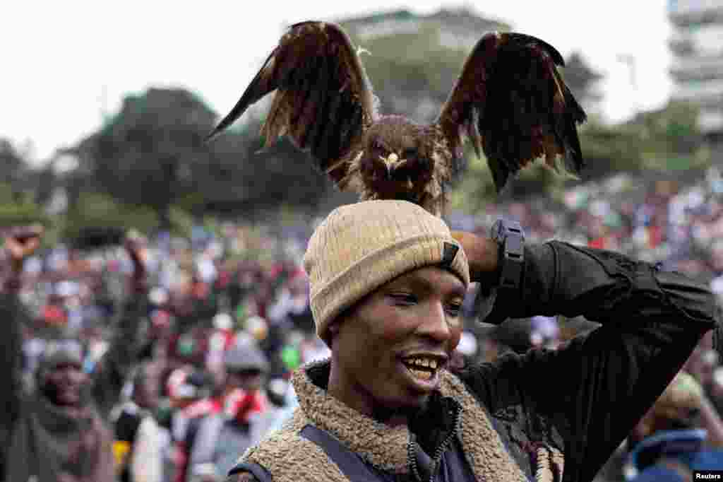 A bird of prey sits on a man's head at a tribute concert held in honor of the people killed in anti-government protests, in Nairobi, Kenya, July 7, 2024.