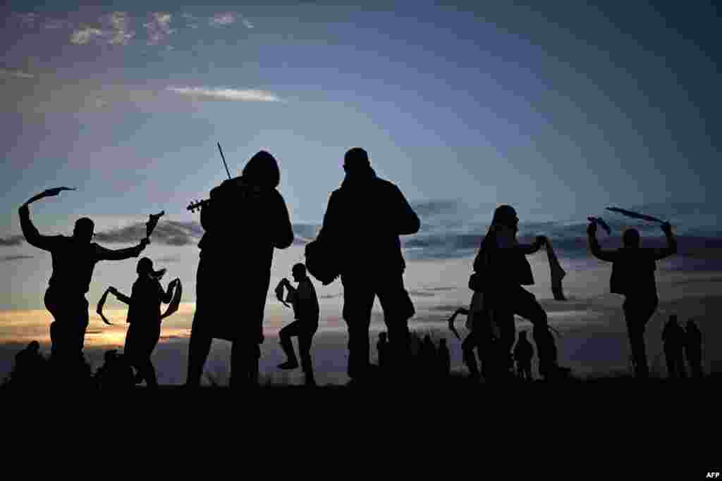 Miserden Morris dancing group performs at sunrise on Rodborough Common, in Stroud, western England, as part of the May Day celebrations.