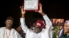 President-elect Bola Tinubu, center, displays his certificate, accompanied by his wife Oluremi Tinubu, right, and chairman of the Independent National Electoral Commission Mahmood Yakubu at a ceremony in Abuja, Nigeria, March 1, 2023.