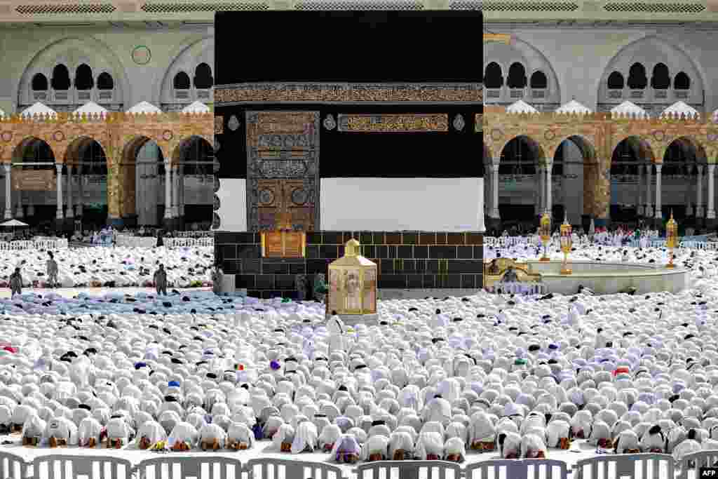 Muslim worshipers pray around the Kaaba, Islam's holiest shrine, at the Grand Mosque in Saudi Arabia's holy city of Mecca as pilgrims arrive ahead of the annual hajj pilgrimage.