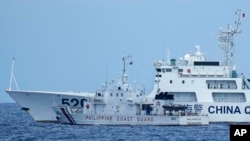 资料照片：2023年4月23日，一艘中国海警船在南中国海有争议海域拦截菲律宾的海岸警卫队巡逻船，险些造成撞船事故。（美联社照片）