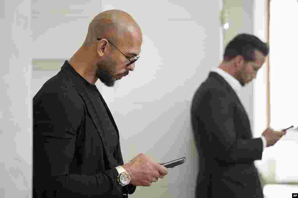 Andrew Tate, left, and his brother Tristan, right, wait inside the Court of Appeals building in Bucharest, Romania.