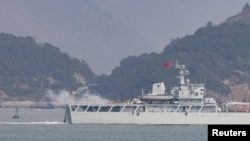 资料照：在靠近台湾金门岛的福建省福州附近海域一艘中国海军战舰在举行军演时开火。（2023年4月8日）