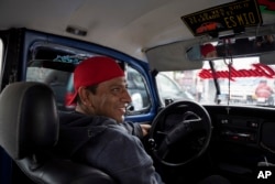 Taxi driver Claudio Garcia sits inside his Volkswagen Beetle he has named "Gualupita" after his wife, in the Cuautepec neighborhood of Mexico City, Friday, June 21, 2024. (AP Photo/Aurea Del Rosario)