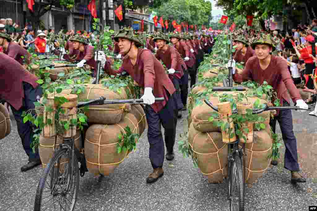 Performers walk with bicycles depicting the transportation of food and necessities to the battlefields during official celebrations of the 70th anniversary of the 1954 Dien Bien Phu victory over French colonial forces in Dien Bien Phu city, Vietnam. 