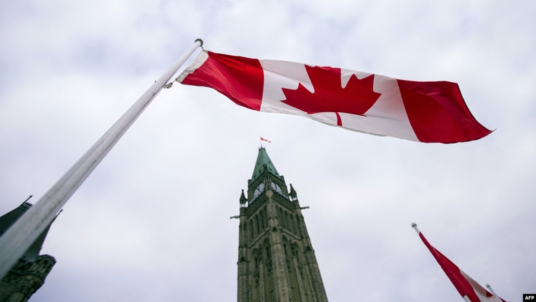 FILE - A Canadian flag flies in front of the peace tower on Parliament Hill in Ottawa, Canada, on Dec. 4, 2015.