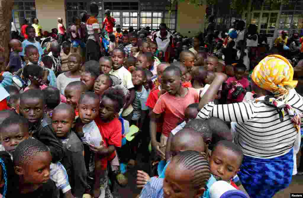 Displaced children queue for food rations at a rescue center after the Nairobi river burst its banks and destroyed their homes within the Mathare valley settlement in Nairobi, Kenya.