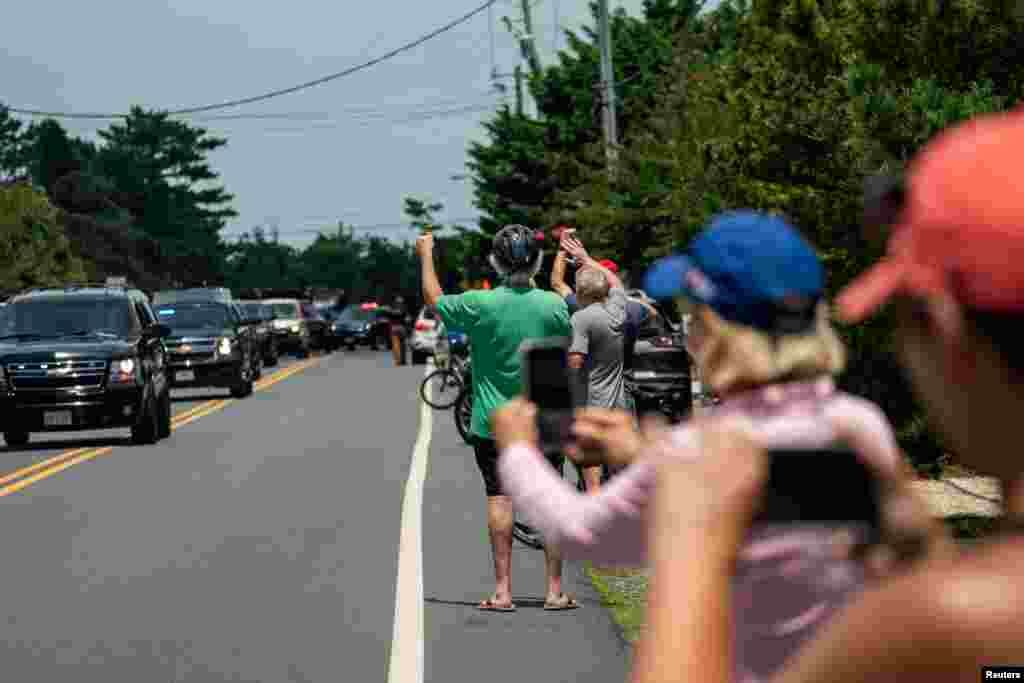 People gather as the motorcade of U.S. President Joe Biden passes through, in Rehoboth Beach, Delaware, July 23, 2024.