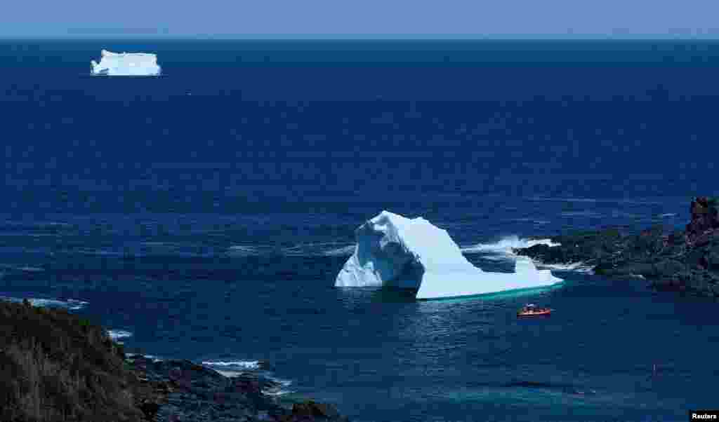 A tour boat is seen near icebergs that drifted south on the Labrador Sea from Greenland, in Saint Lunaire-Griquet, Newfoundland, Canada, May 27, 2024.