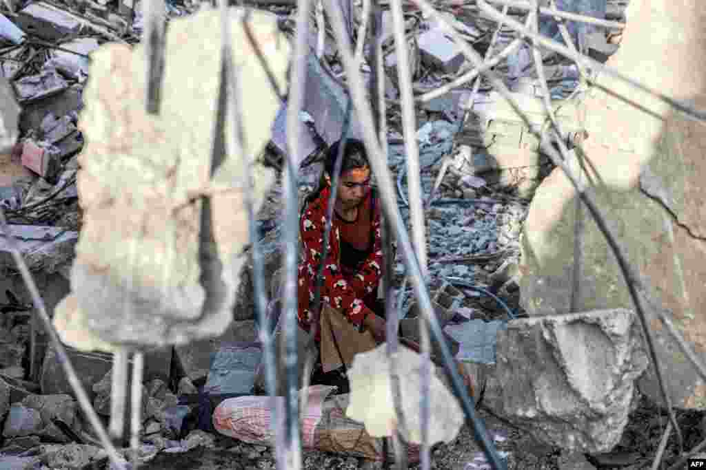 A girl salvages items from the rubble of a collapsed building in Rafah in the southern Gaza Strip, following reported Israeli airstrikes overnight.