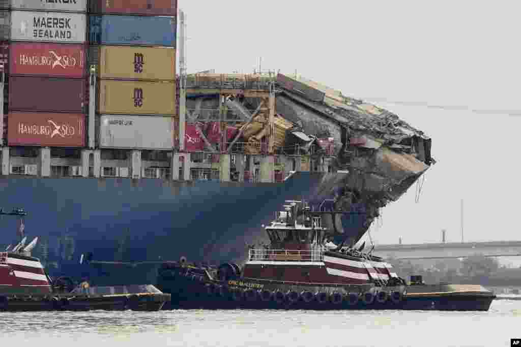 Tugboats escort the cargo ship Dali after it was refloated in Baltimore, Maryland. The vessel on March 26 struck the Francis Scott Key Bridge causing it to collapse and resulting in the death of six people.