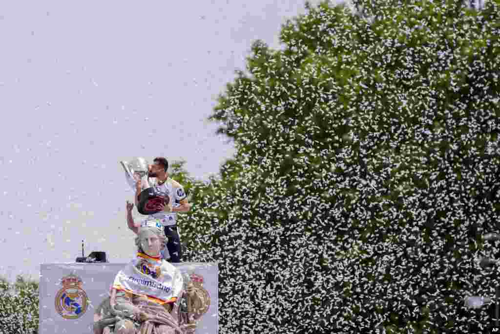 Real Madrid's Nacho Fernandez holds their 36th Liga trophy during celebrations at the Cibeles Square a week after clinching Spanish La Liga soccer title in Madrid, Spain.