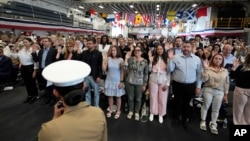 Novi američki državljani polkažu zakletvu Sjedinjenim Državama, tokom ceremonije naturalizacije u Majamiju, 7. maja 2024. godine.