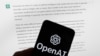 资料照片：2023年3月21日波士顿，“开放人工智能”（OpenAI ）徽标在电脑屏幕前的手机上，电脑屏幕显示的是ChatGPT 的输出。（美联社照片）