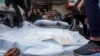 Palestinci utovaruju tijela svojih rođaka ubijenih u izraelskom bombardovanju pojasa Gaze u kamion, koji će biti pokopani na groblju u Deir al Balahu, Pojas Gaze, 25. decembra 2023.