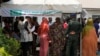 FILE - People queue to collect their elections permanent voters cards at a distribution center.