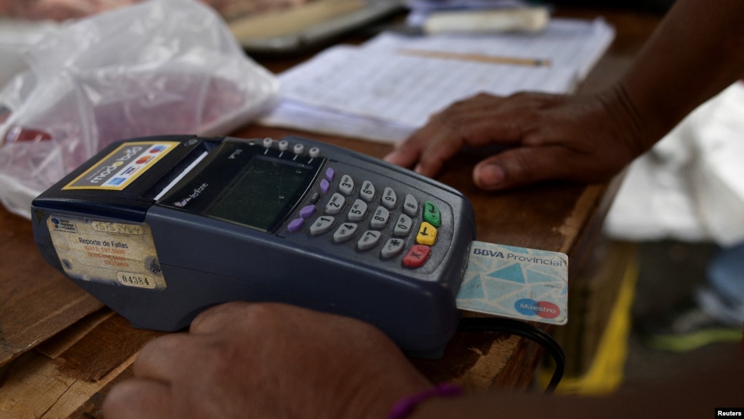 Un vendedor procesa un pago en un punto de venta en un mercado de Caracas el 10 de febrero de 2023. REUTERS/Gaby Oraa