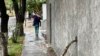 Una mujer se resguarda de la lluvia con un paraguas mientras camina por una calle del este de Caracas el 30 de mayo de 2023. 