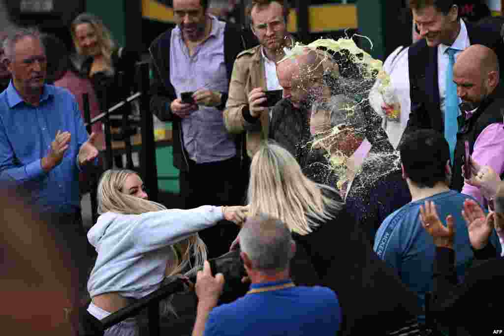 A person throws a drink in the face of Nigel Farage, newly appointed leader of Britain's right-wing populist party, Reform UK, during his general election campaign launch in Clacton-on-Sea, eastern England.