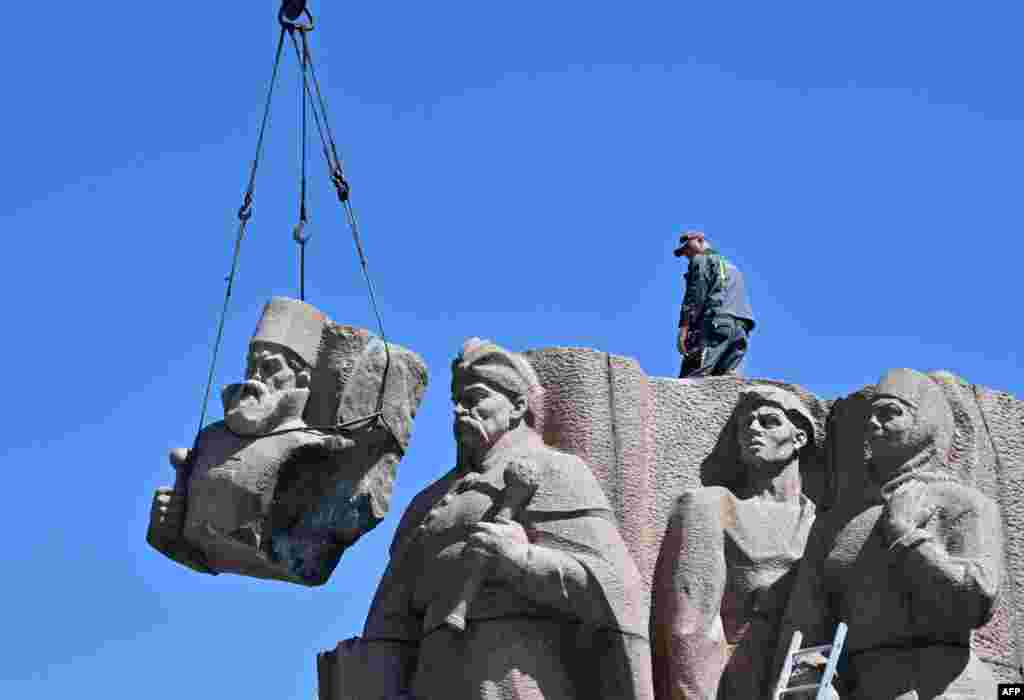 Workers dismantle the Soviet-era monument symbolizing the Pereiaslav Agreement signed in 1645, a pledge of allegiance by Ukranian Cossacks to the Tsar of Russia, in Kyiv.