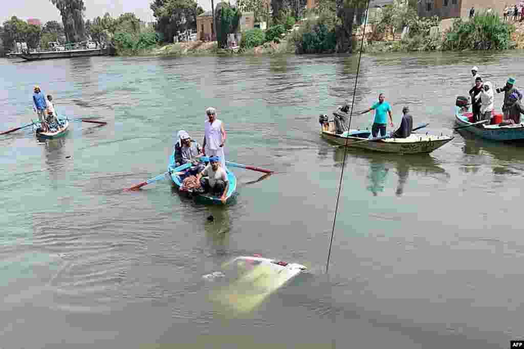 Rescuers work to pull a sunken minibus from a canal of the Nile River near Abu Ghaleb village in Egypt's Giza governorate. At least 10 farm workers died when a minibus plunged off a river ferry and into the Nile northwest of Cairo, the health ministry said.