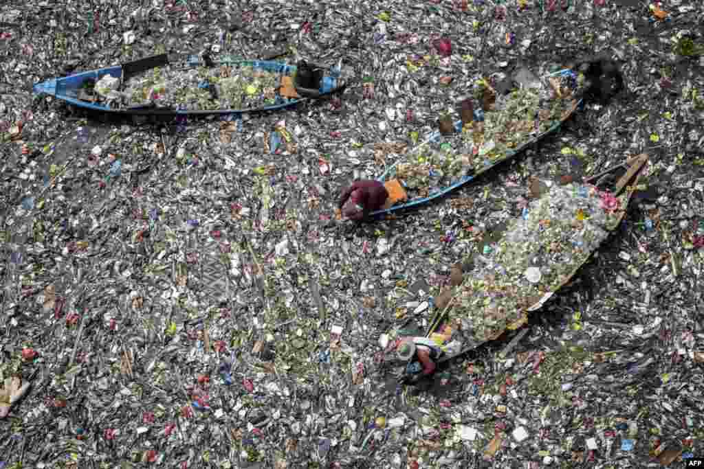 People on boats collect recyclable plastics from the heavily polluted Citarum River at Batujajar in Bandung, West Java, Indonesia.