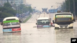 তানজানিয়ার দার এস সালামের জলমগ্ন রাস্তায় আটকে রয়েছে মিনিবাস। ফটোঃ ২৫ এপ্রিল, ২০২৪। 