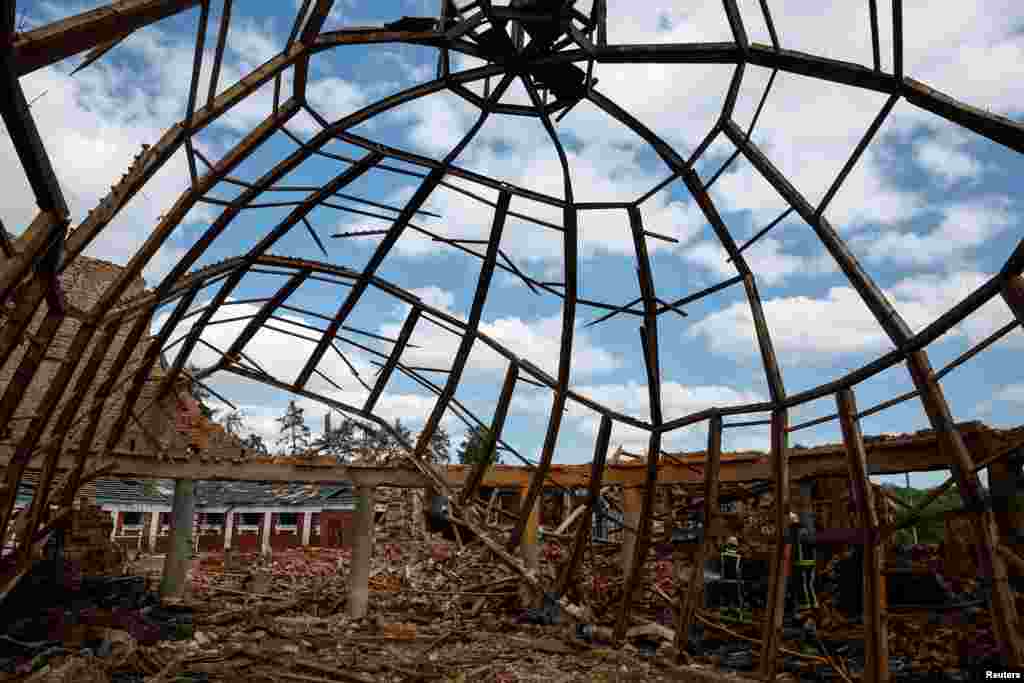 Firefighters work at the site of the Kids and Youth Sport Riding School, which was heavily damaged by Russian missile strikes, amid Russia's attack on Ukraine, in the village of Mala Danylivka, outside of Kharkiv, Ukraine.