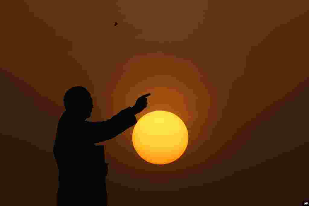 The sun sets behind a statue of Bhimrao Ramji Ambedkar, the chief architect of the Indian Constitution, in Hyderabad, India.