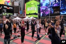 People participate in a yoga class during the "Times Square: Mind Over Madness Yoga" event, to celebrate the summer solstice June. 21, 2023, in New York. (AP Photo/Yuki Iwamura)