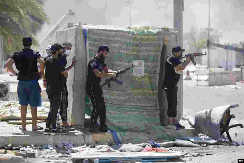 Armed members of Saraya al-Salam (Peace Brigade), the military wing affiliated with Shiite cleric Moqtada al-Sadr, are seen during clashes with Iraqi security forces in Baghdad's Green Zone.