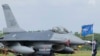 A Taiwanese Air Force flag bearer passes by one of the newly commissioned upgraded F-16V fighter jets at Air Force base in Chiayi in Taiwan, Nov. 18, 2021. 